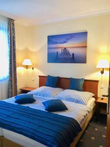 a bedroom with a bed with blue pillows on it at Ferienwohnung Seeblick - Insel Usedom in Balm