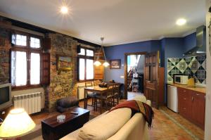 un soggiorno con divano e cucina di Apartamentos Casa María Juanín a Collanzo