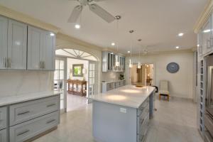 a large kitchen with white cabinets and a ceiling fan at Royal Palms, St James in Saint James