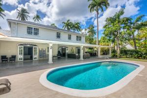 a swimming pool in front of a house at Royal Palms, St James in Saint James