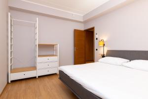 1 dormitorio con cama blanca y armario en Self-check-in 2 bedroom apartment with a terrace and free parking, en Tallin