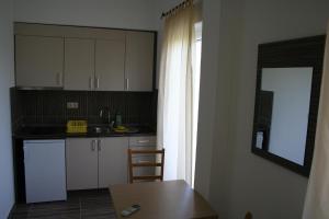 a kitchen with white cabinets and a wooden table at Apartments Paninich in Međugorje