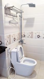 un bagno con servizi igienici bianchi e sedile alzato di Tôm Hùm Palace a Cam Ranh