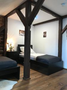 two beds in a room with wooden beams at Wieko Ferienwohnungen - Luxus Pur im Prinz von Preußen in Bad Elster