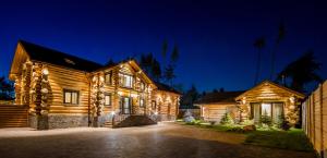 a log house at night with lights on it at Банний клуб Столичний in Vita-Pochtovaya