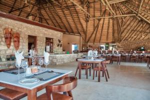 uma sala de jantar com mesas e cadeiras num edifício em Agama Lodge em Solitaire