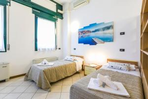 two beds in a room with windows at Casa Temporanea in Bologna