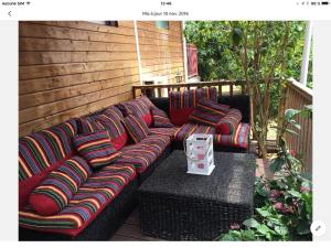 un sofá negro con almohadas coloridas en el patio en La Kaze Cocos, en Pierrefonds