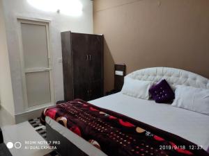 1 dormitorio con 1 cama grande y armario en THE HIMALAYAS GUEST HOUSE, en Dharamshala