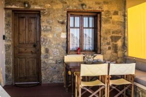 una cucina con tavolo, sedie e finestra di Seaview Symphony Appartments-Yiannis a Mochlos