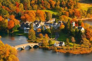 a town with a bridge over a river with trees at A Fairytale Highland Cottage in Aberfeldy