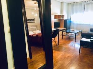 a room with a bed and a table and a mirror at Apartamentos Confortarte in Oviedo