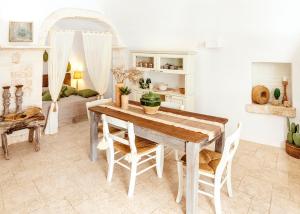 una sala da pranzo con tavolo e sedie in legno di Alesia luxury suite Ostuni a Ostuni