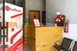 a hotel room with a bed and a desk with flowers at RedDoorz near Sam Poo Kong 3 Semarang in Kalibanteng-lor