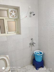 een badkamer met een douche en een emmer bij THE HIMALAYAS GUEST HOUSE in Dharamshala