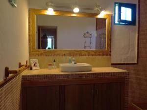 a bathroom with a sink and a large mirror at Casa Mi Tio Perico in Mala