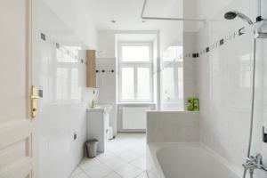 um banheiro branco com banheira e chuveiro em UNIVERSUM APARTMENT 2 em Viena mais 26 fotografias