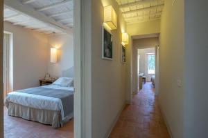 1 dormitorio con 1 cama y pasillo en Villa Severina, en Cortona