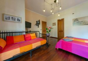 two beds in a room with colorful pillows at AnnoDomini in Rome