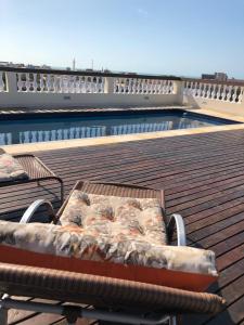 um banco num deque ao lado de uma piscina em Angra Praia Hotel em Fortaleza