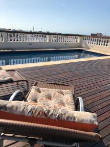 a bench on a deck next to a swimming pool at Angra Praia Hotel in Fortaleza