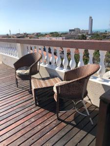 2 stoelen op een balkon met een leuning bij Angra Praia Hotel in Fortaleza