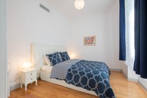 a white bedroom with a bed and a white couch at Le Beau Rivage in Nice