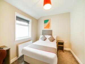 a bedroom with a bed and a window at OYO Tequila and Dunlin Rooms Southport Central in Southport