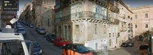 a city street with cars parked next to a building at Renovated 16th Century House in Valletta in Valletta