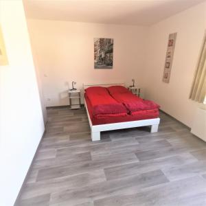 een slaapkamer met een rood bed in een witte kamer bij Apartment außen Pfui innen Hui in Mönchengladbach