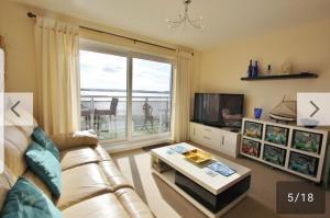 a living room with a couch and a large window at island reach in Poole