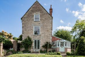 uma antiga casa de tijolos com um jardim de Inverno em frente em Magnificent Clarence cottage! em Swanage