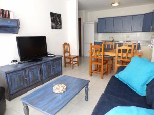 Una sala de estar con un sofá y una mesa con televisión. en Apartamentos Medano - Mirazul 2, en El Médano 12 fotos más