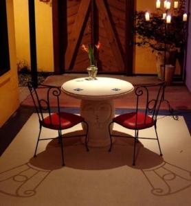 a table with two chairs and a vase on it at Pink Flamingo Resort in Port Douglas