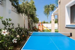 una piscina en un patio trasero con pista de tenis en Aria Villas, modern paradise, By ThinkVilla, en Pigi