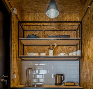 a kitchen with wooden shelves and a sink at Kazbegi 5054 in Kazbegi