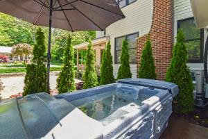 a hot tub in front of a house with an umbrella at Lucky Lucy in Saugatuck