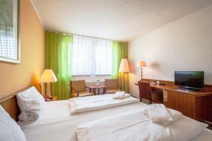 a hotel room with two beds and a desk at Interhotel Bohemia in Ústí nad Labem