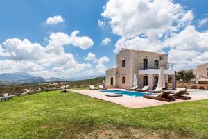 an external view of a villa with a swimming pool at Dimokritos Villas IV, V, & VI, a homestay experience, By ThinkVilla in Angeliana