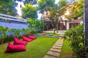 a garden with red pillows on the grass at Legian Family villa with pool in Legian