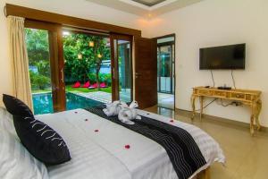 a bedroom with a bed with two stuffed animals on it at Legian Family villa with pool in Legian +135 photos