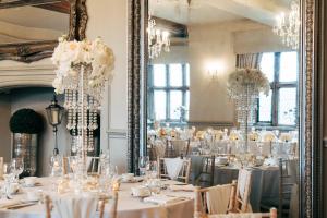 a room full of tables with white tablecloths at Weston Hall in Stafford