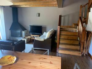 a living room with a staircase and a television at Can Marc de Pi, Bellver de Cerdanya in Pi