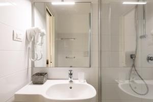 a white bathroom with a sink and a shower at bellaMI in Milan
