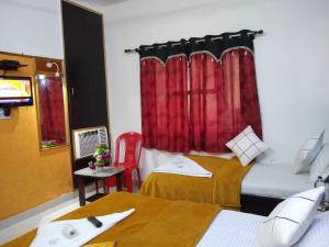 - une chambre avec 2 lits et un rideau rouge dans l'établissement Agra Paying Guest House, à Agra