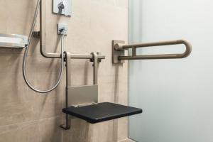 a shower stall with a black bench in a bathroom at Hotel Post in Nauders