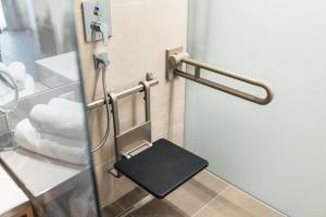 a bathroom with a door with a small stool at Hotel Post in Nauders