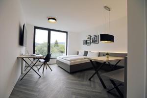 - une chambre avec un lit, un bureau et une table dans l'établissement Saminapark Aparthotel, à Frastanz