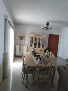 a dining room with a wooden table and chairs at Dora's Apartment 5 min from airport in Spata