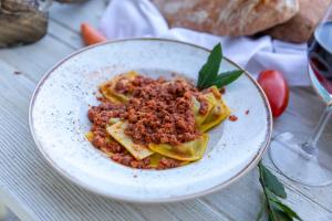 a plate of pasta with meat on a table at Agriturismo La Mignola in Quercianella